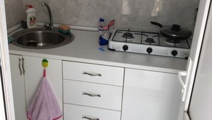 A kitchen with a sink, faucet, stove, and cabinets. - Hotel Guesthouse Lola (Batumi)