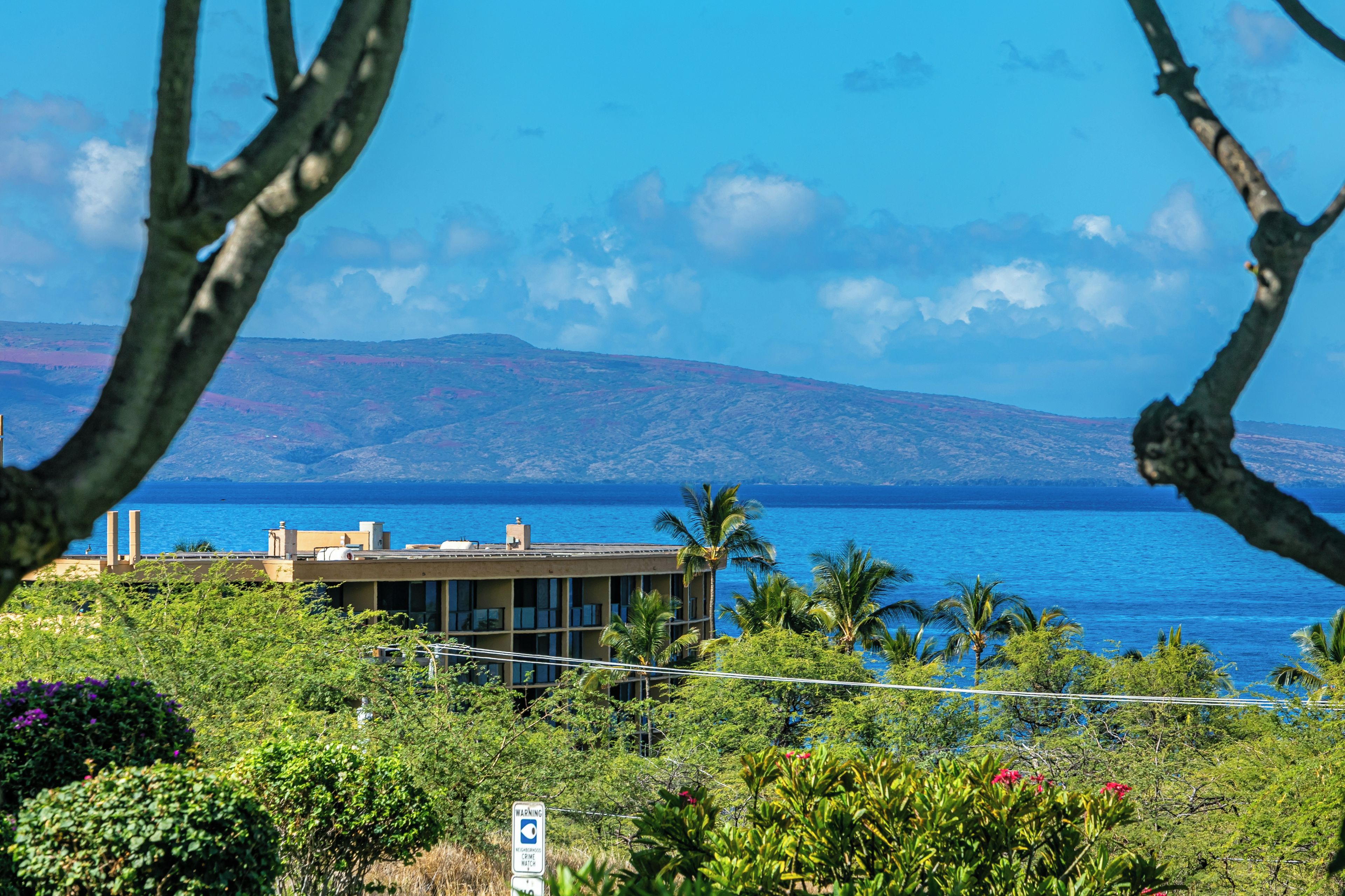A coastal building with a view of the sea and mountains.