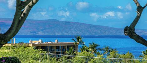 A coastal building with a view of the sea and mountains.