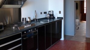 A modern kitchen with a stainless steel range hood, a built-in oven, and a coffee maker. - Live a unique 'provencale' experience in the heart of the Luberon (Apt)