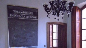 A room with a sofa, a glass coffee table, a chandelier, and a wall-mounted book titled "Walt Whitman The Complete Poems". - Live a unique 'provencale' experience in the heart of the Luberon (Apt)