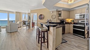 A spacious kitchen with a large island, modern appliances, and a view of the ocean.