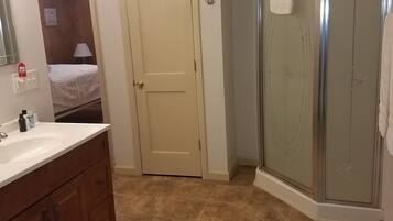 A bathroom with a shower, a sink, and a mirror.