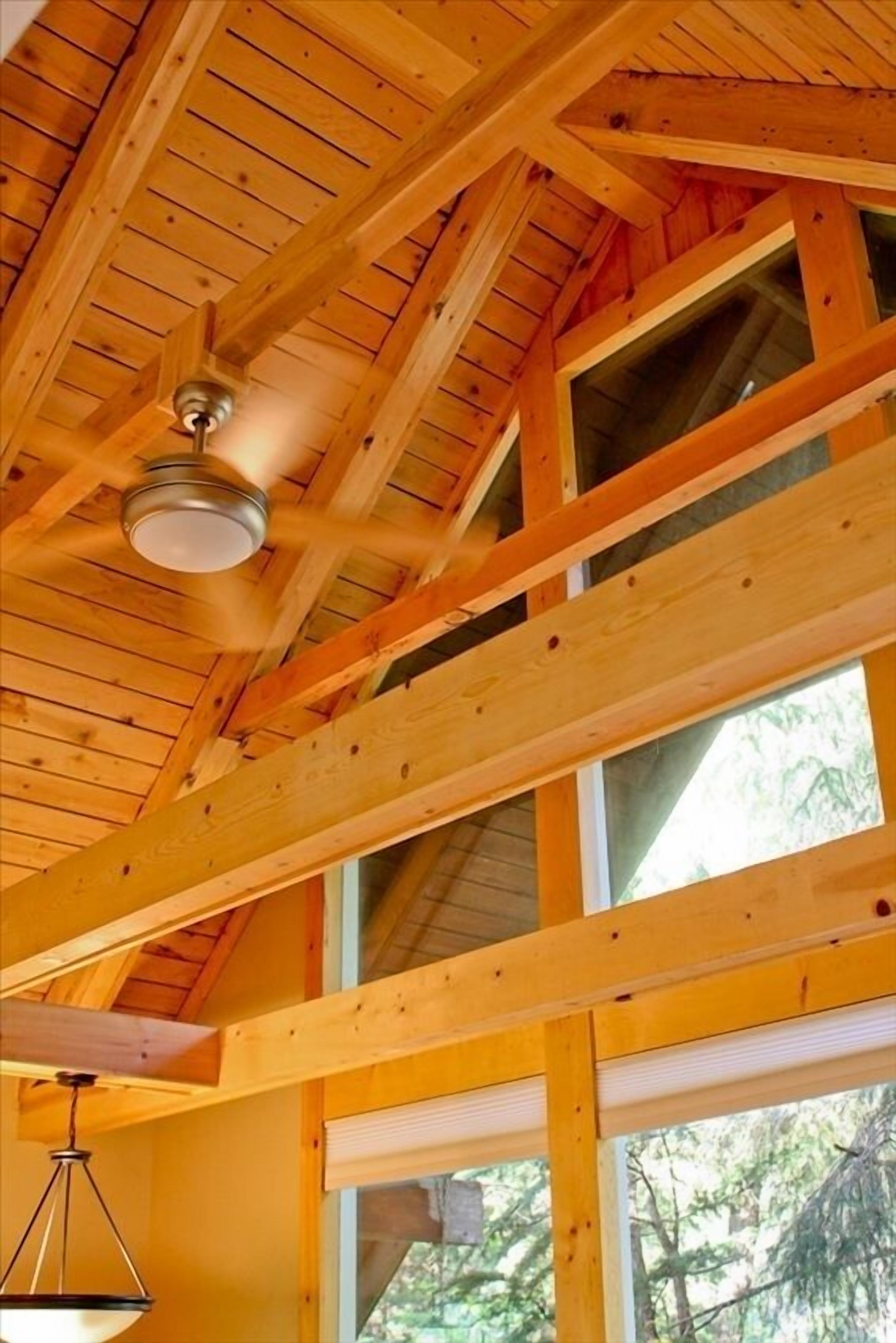 A wooden ceiling with exposed beams and a ceiling fan.