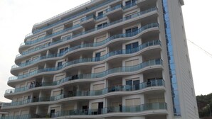 Ein mehrstöckiges Wohngebäude mit Balkonen und modernem architektonischen Design.