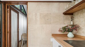Una cocina con encimera de madera, un lavabo y un florero con flores.
