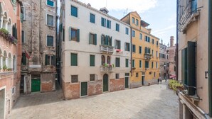 A narrow street with historic buildings, including a building with a sign that reads "Hotel del Pescatore."