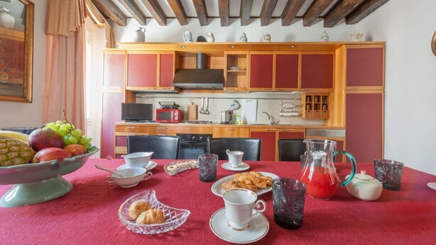 A breakfast setup with a table set for two, including fruits, pastries, and beverages.
