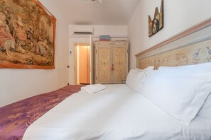 Ein Hotelzimmer mit einem großen Bett, einem Schrank und einem Gemälde an der Wand.