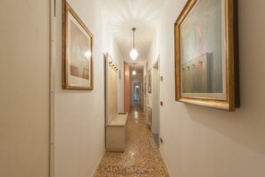 A hallway with framed artwork on the walls, a bench, and a light fixture. - Ve.N.I.Ce. Cera Casa Del Sol (Venezia)