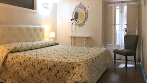 Ein Schlafzimmer mit Bett, Stuhl, Spiegel und einer Tür.
