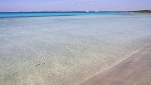 A clear beach with shallow water and a distant shoreline. - TRULLO WITH POOL SEA VIEW - GALLIPOLI - SOUTH TOWER - JUST RENOVATED (Torre Suda)