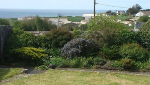 Un village côtier avec des maisons, un mur de pierre et une vue sur la mer.