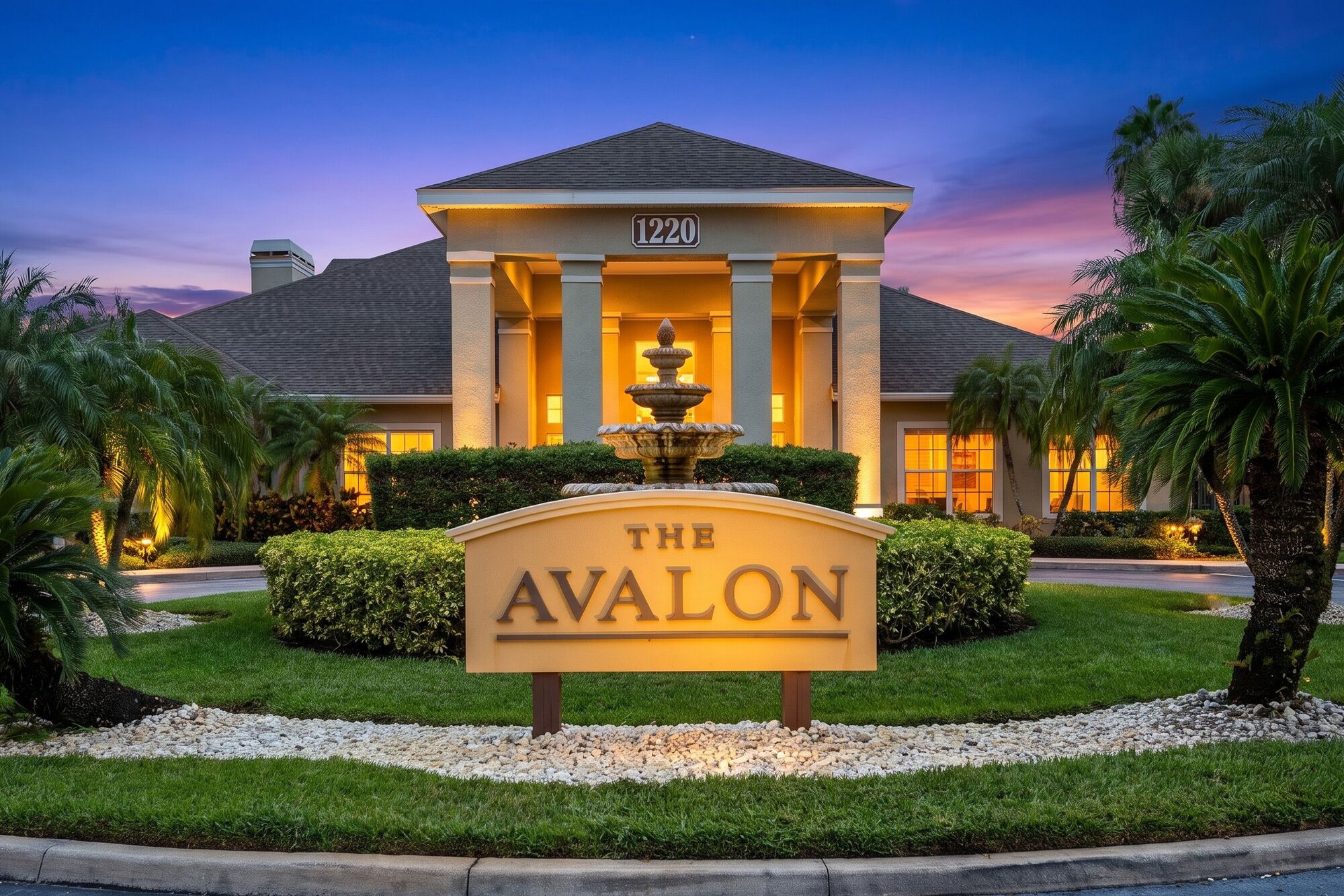 A hotel entrance with a sign reading 'The Avalon' and a fountain in front.