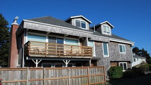 A two-story house with a wooden deck, a garage, and a satellite dish. - 3Bed/2Ba Absolutely Beautiful Home just off Prom with Ocean Views (Seaside)