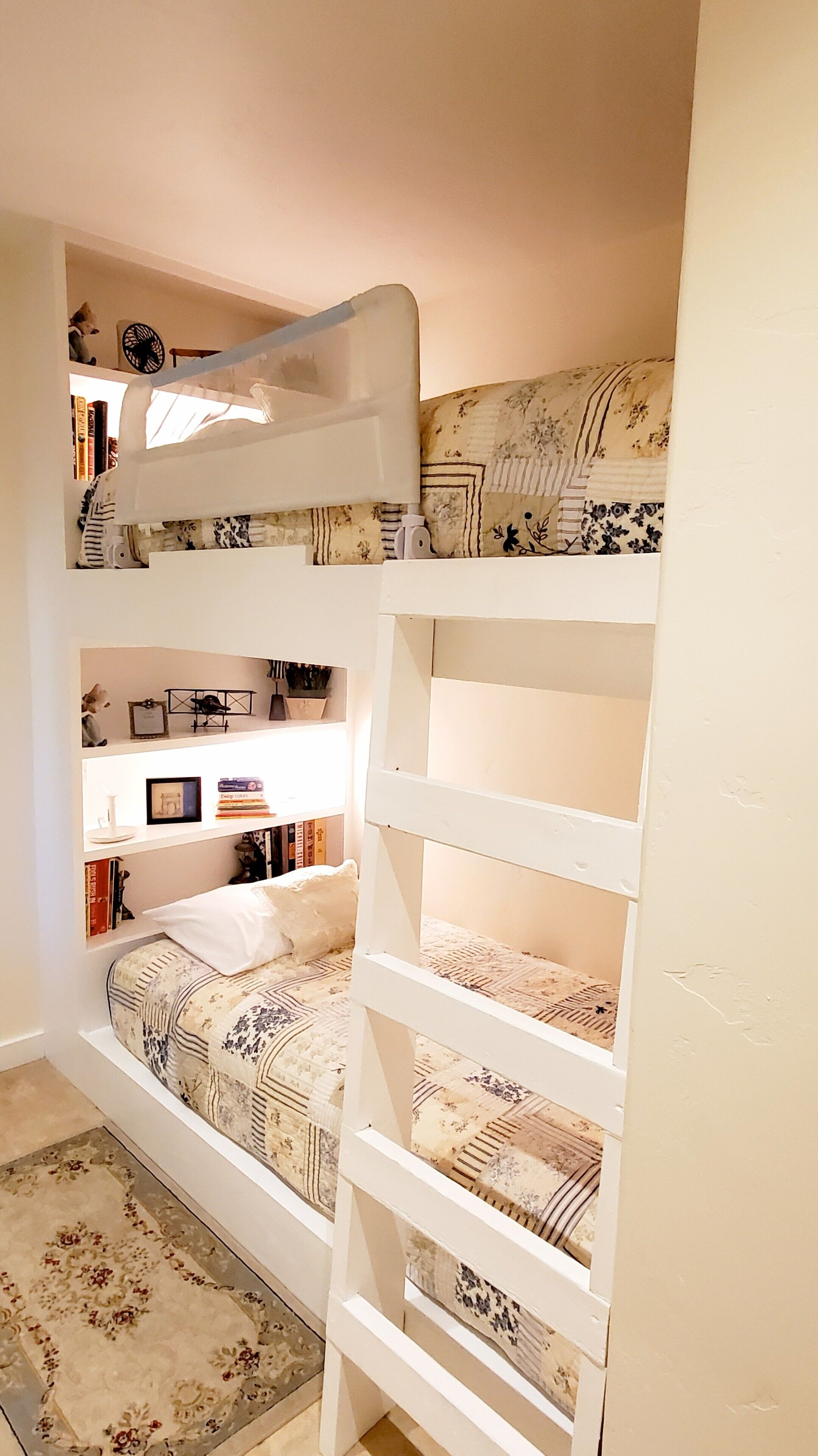 Habitación con literas, escritorio y estanterías.