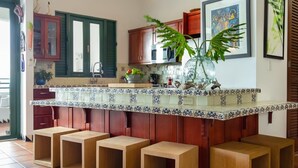 Una cocina con armarios de madera, salpicadero de azulejos y una isla central con taburetes.