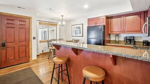 A modern kitchen with wooden cabinets, a granite countertop, and a stainless steel refrigerator. - All Seasons 2BR | Walk to Park City Mountain | Heated Pool | Sleeps 6 (Park City)