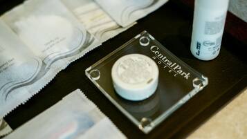 A tray with various toiletries including a bottle of Central Park brand lotion, a small container, and some tissue paper.
