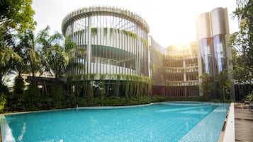 Een buitenzwembad, parasols bij het zwembad en ligstoelen