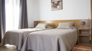 Et hotelværelse med to senge, et træhovedgærde, et natbord med en lampe og et billede på væggen.
