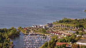 Un port de plaisance où sont amarrés de nombreux bateaux, entouré de bâtiments résidentiels et de verdure.