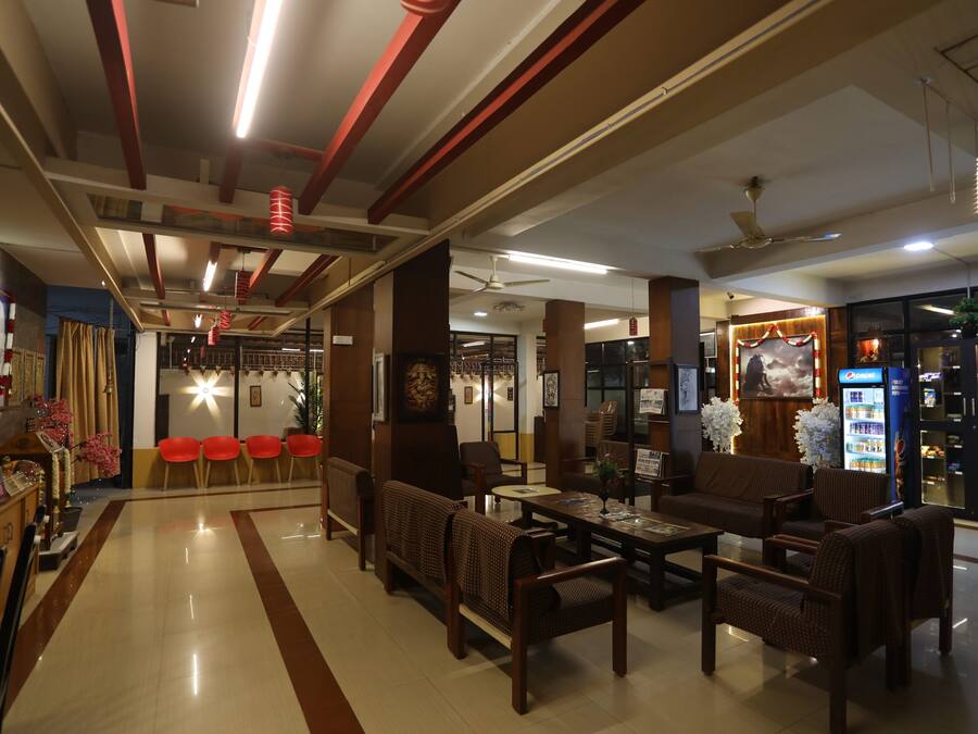 A hotel lobby with a reception desk, seating area, and a vending machine.