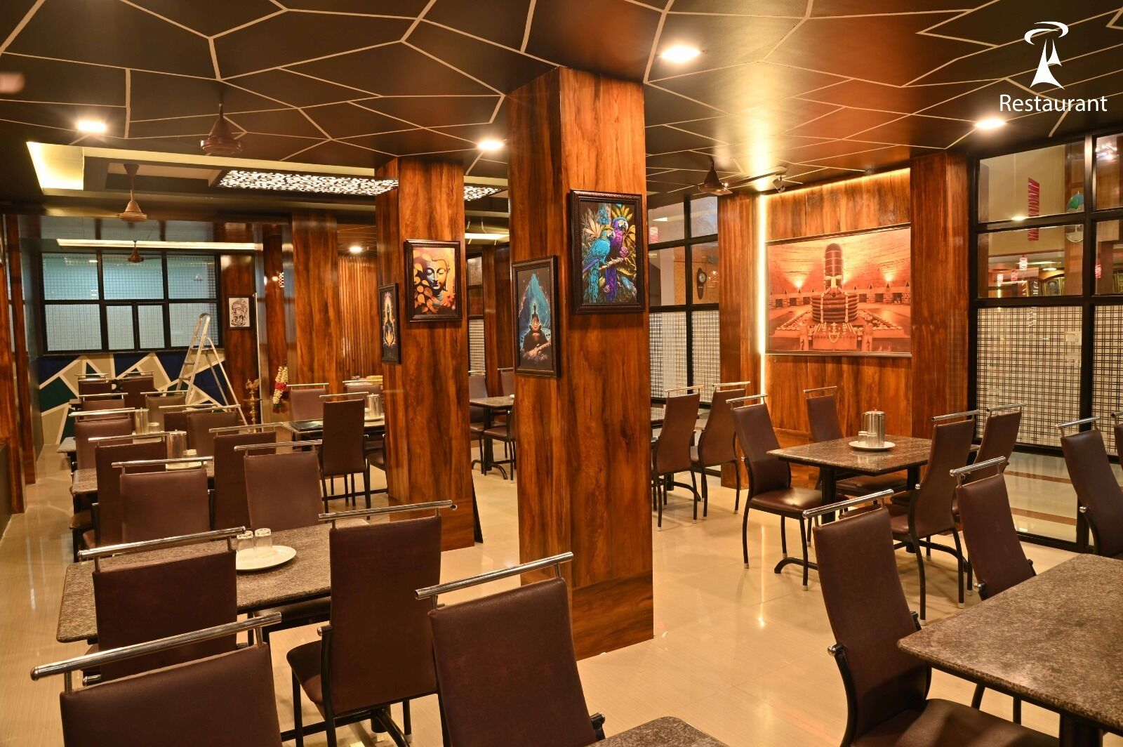 Interior de restaurante con paneles de madera, obras de arte enmarcadas y una combinación de asientos tipo cabina y mesas.