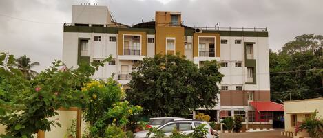 A multi-story building with a parking area in front.