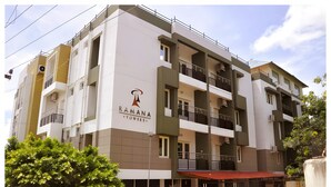 A multi-story building with balconies, a sign reading "RAMANA TOWERS," and a red awning. - Ramana Towers (Tiruvannamalai)