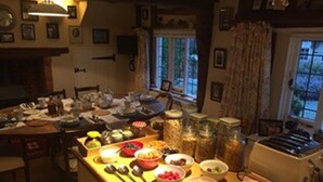 Une cuisine avec un plan de travail en bois, divers aliments, des bocaux et un grille-pain.
