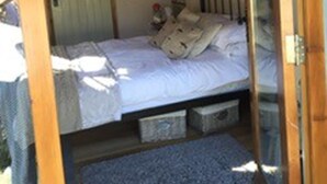 Une chambre à coucher avec un lit, une commode, un miroir et une fenêtre.