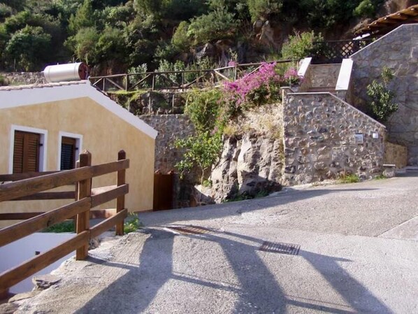 Un edificio rústico con un muro de piedra y una cerca de madera.