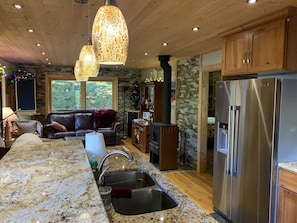 A modern kitchen with granite countertops, stainless steel appliances, and a wooden dining area.