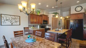 A kitchen with wooden cabinets, granite countertops, a chandelier, and a clock on the wall. - STUNNING/IMMACULATE4bd/2ba PrivatePool/WaterSLIDE new beds!!BOOK (Washington)