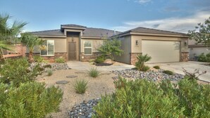 A single-story house with a garage, a front yard with various plants, and a clear sky. - STUNNING/IMMACULATE4bd/2ba PrivatePool/WaterSLIDE new beds!!BOOK (Washington)