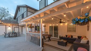 A covered outdoor patio with a dining area, seating, and a bar. - Private Pool, Mini Golf, Game Room & Fire Pit near Six Flags (San Antonio)