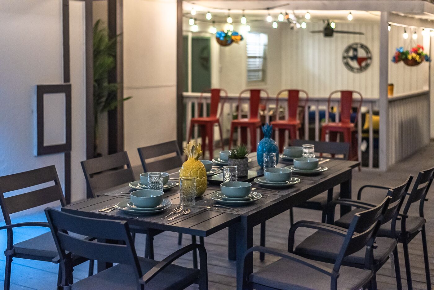 A dining area with a long table set for a meal, surrounded by chairs.