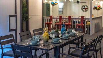A dining area with a long table set for a meal, surrounded by chairs.