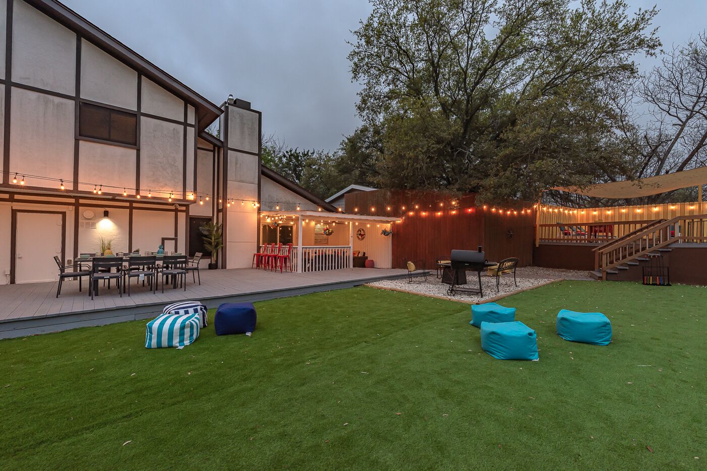 A modern outdoor patio with a dining area, barbecue, and seating.