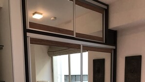 Un dormitorio con cama, ventana y espejo.