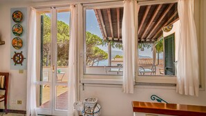 Une chambre avec vue sur la mer, un plafond en bois et un sol carrelé.