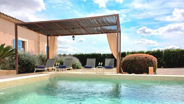 Piscina com espreguiçadeiras e área coberta.