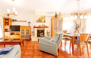 Una sala de estar con chimenea, muebles de madera y televisor.