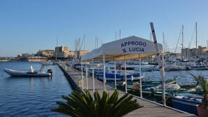 A marina with boats docked, a covered area labeled "APPRODO S. LUCIA", and a clear sky. - New on Homeaway- totally renovated and air-conditioned independent house   (Siracusa)