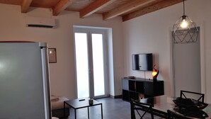 A modern kitchen with a dining area, a TV mounted on the wall, and a large window. - New on Homeaway- totally renovated and air-conditioned independent house   (Siracusa)