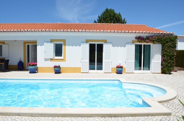 A building with a swimming pool, white exterior walls, and a tiled roof. - Beautiful & Exotic Villa at Vale da Telha, Arrifana, Aljezur (Aljezur)