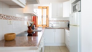 A modern kitchen with white cabinets, a granite countertop, and a built-in oven. - LUXURY SUNNY HOLIDAY HOME WITH BREATHTAKING VIEWS AND HEATED PRIVATE POOL (Amarilla Golf)