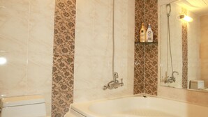 Un baño con inodoro, bañera y ducha.