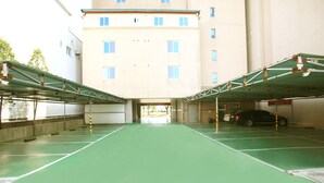 Un estacionamiento subterráneo con varios niveles y piso verde.